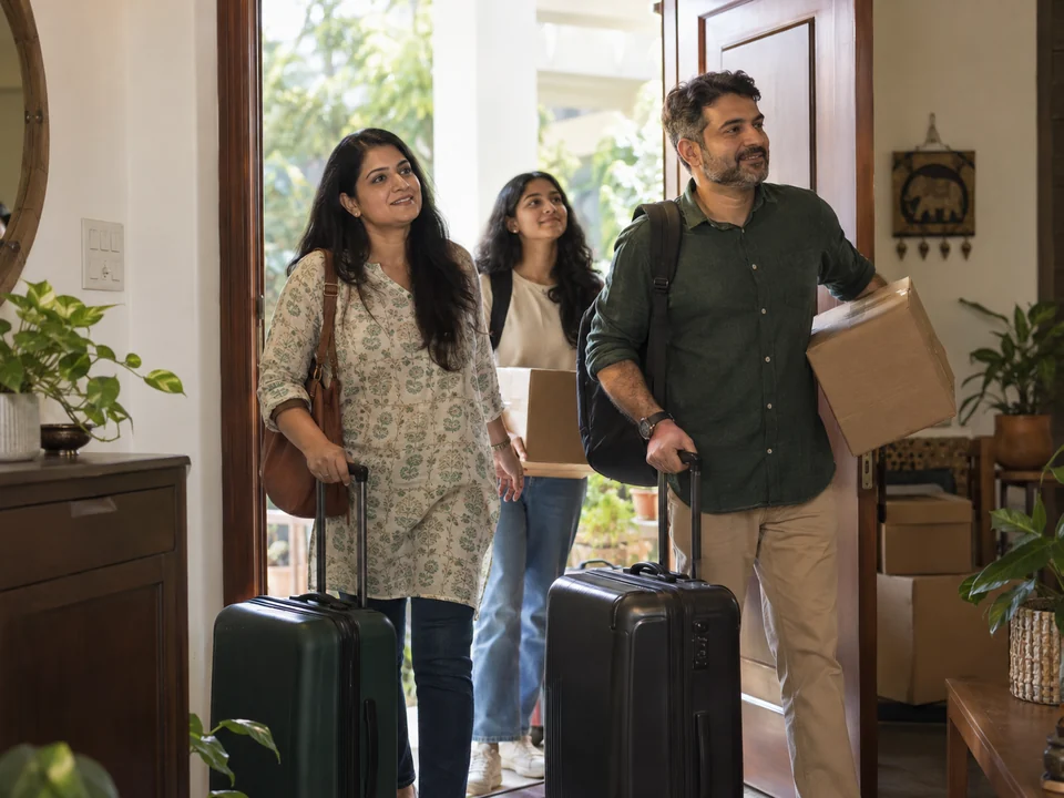 AI-generated illustration of an Indian family arrives at a bright home doorway with suitcases and moving boxes.